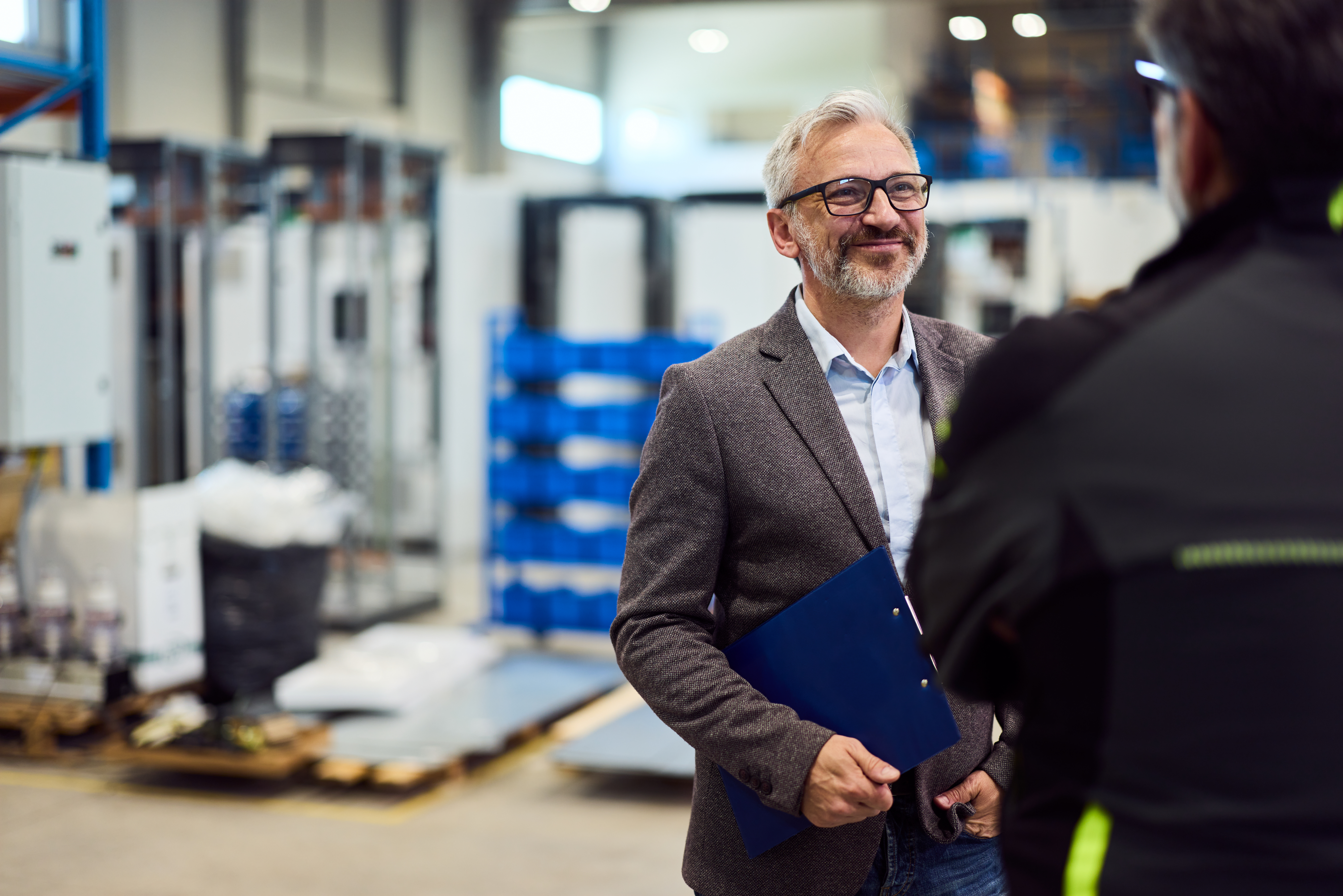 manager discussing business strategies in a modern industrial setting with team