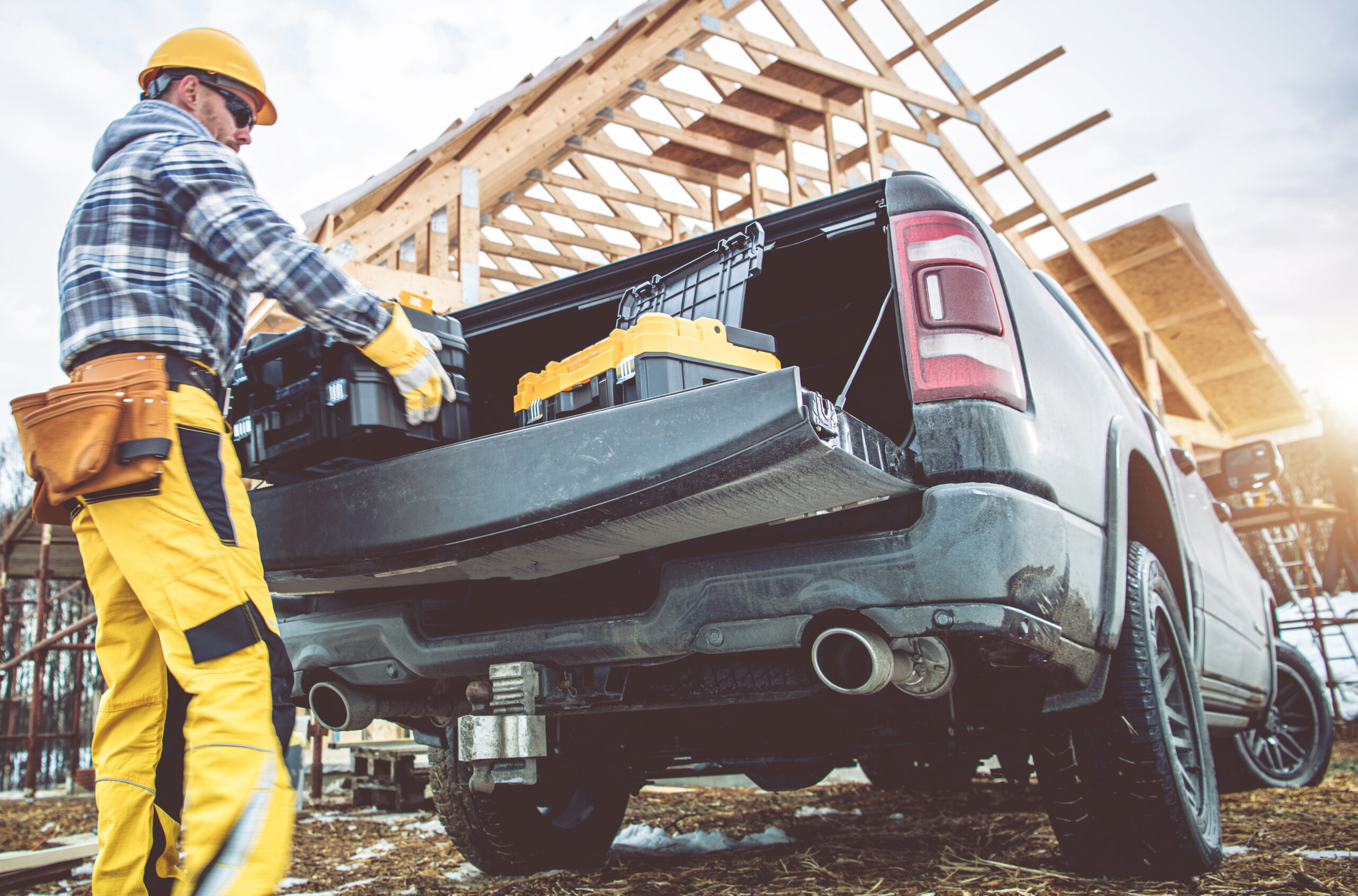 construction worker taking tools boxes from his pickup truck