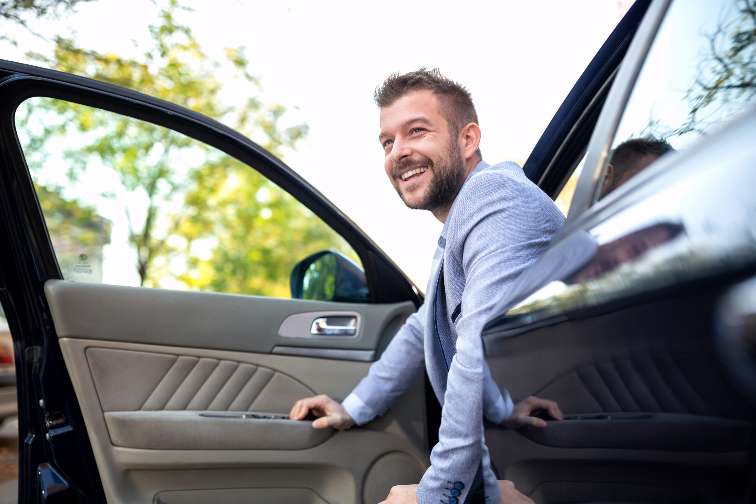 smiling man exiting his vehicle